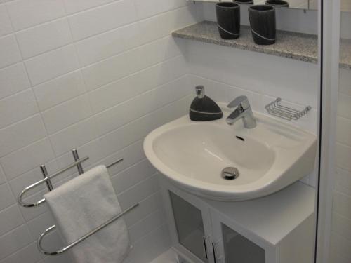 een witte badkamer met een wastafel en een handdoek bij Ferienwohnung Waldblick in Braunlage