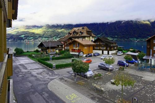 a large building with cars parked in a parking lot at Switzerland Iseltwald Apartment in Iseltwald