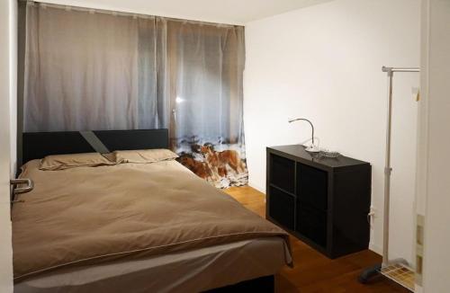 a bedroom with a bed and a dresser and a window at Switzerland Iseltwald Apartment in Iseltwald