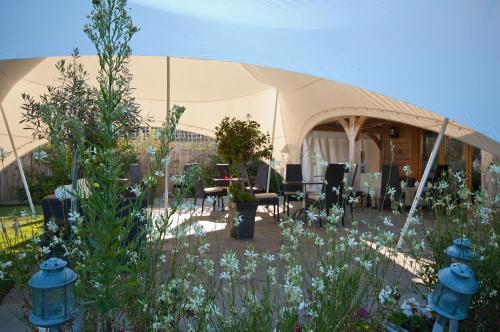 a tent with tables and chairs in a garden at Frasers in Egerton