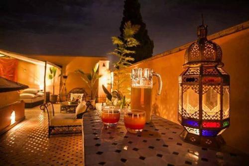 a table with two glasses of beer and a lantern at Riad Abjaou in Marrakech