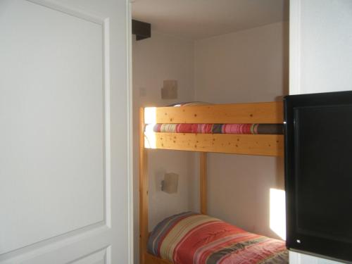 a bedroom with a bunk bed and a television at Serre-Chevalier Chantemerle Eterlou in Saint-Chaffrey