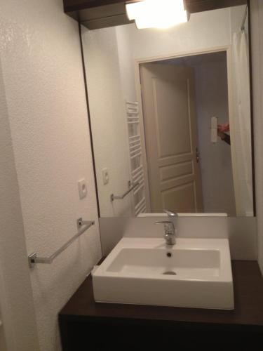 a bathroom with a sink and a large mirror at Serre-Chevalier Chantemerle Eterlou in Saint-Chaffrey