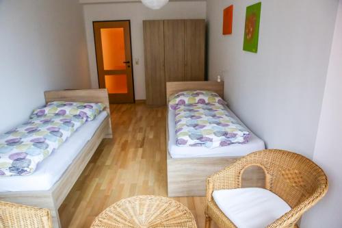 ein Zimmer mit 2 Betten und einem Stuhl darin in der Unterkunft Apartment Nepomuk in Kirchberg an der Pielach