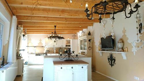 eine Küche mit weißen Schränken und einem Kronleuchter in der Unterkunft Gästehaus Liebler in Rothenburg ob der Tauber