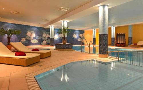 eine Hotellobby mit einem Pool und einem Hotel in der Unterkunft Strandhotel Seerose in Ostseebad Kölpinsee