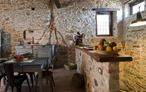 a kitchen with a table with a bowl of fruit on the counter at Residenza d'Epoca Borgodifiume in Fiumefreddo Bruzio