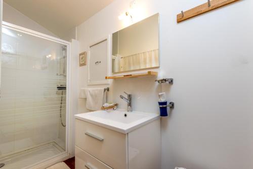 a white bathroom with a sink and a shower at Les Chambres de Jeannette in Marseille