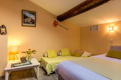 a hotel room with two beds and a table at Les Chambres de Jeannette in Marseille