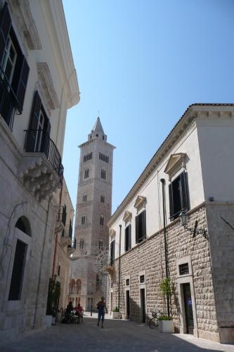 a building with a clock tower in a street at Il Moretto in Trani