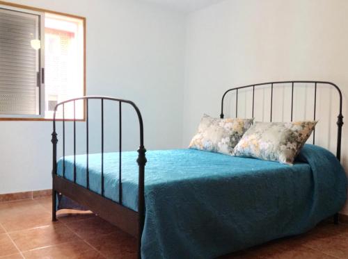 sypialnia z łóżkiem z niebieską pościelą i oknem w obiekcie Casa Miramar w mieście Santa Cruz de Tenerife