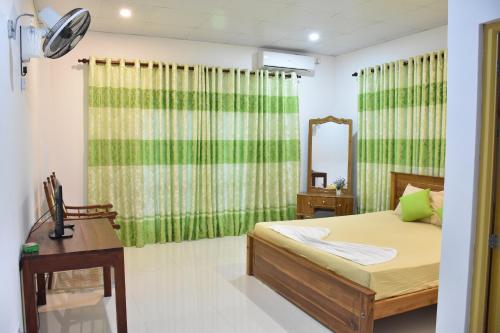 
a bedroom with a bed and a dresser at Green Palace Hotel in Anuradhapura
