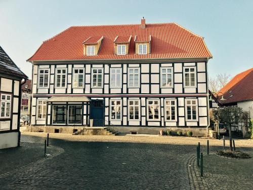 a large black and white building with a red roof at Alte Apotheke in Bad Essen