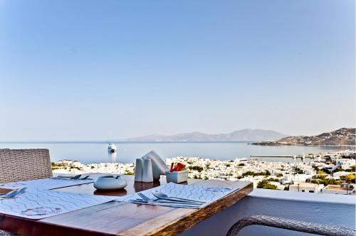 a table on a balcony with a view of a city at Ibiscus Boutique in M&yacute;konos City