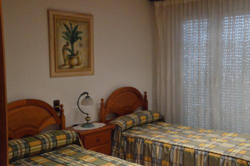a hotel room with two beds and a window at Casa vitorianet in Alcampel