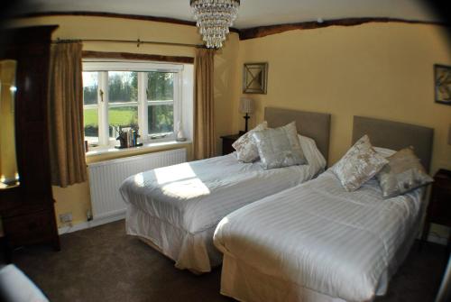 a bedroom with two beds and a window at The Bowl Inn in Charing
