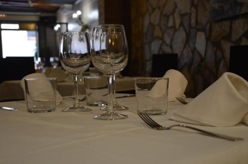 una mesa con cuatro copas de vino en una mesa en Casa vitorianet, en Alcampel