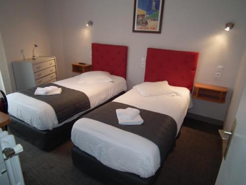 a hotel room with two beds and a dresser at Hôtel de l'Aviation in La Bourboule