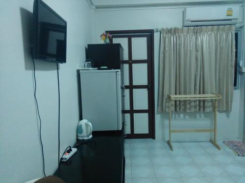 a living room with a refrigerator and a television at NB House in Karon Beach