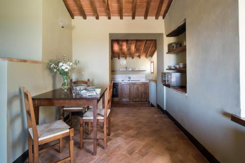 a kitchen and dining room with a table and chairs at Borgo dé Brandi in Monteriggioni