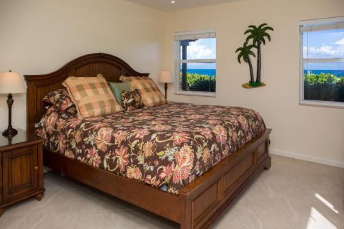 a bedroom with a bed and two windows at Royal Flamingo Villas in Hillsboro Beach
