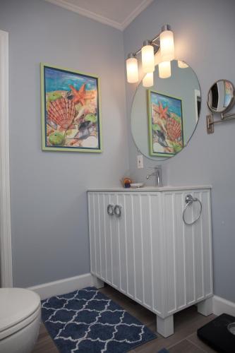 a bathroom with a sink and a toilet and a mirror at Royal Flamingo Villas in Hillsboro Beach