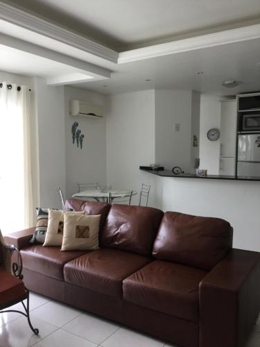 a brown leather couch in a living room at Residencial Ametista - 250 metros do mar in Florianópolis