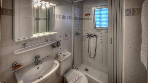 a bathroom with a sink and a shower at Zina Hotel Apartments in Athens
