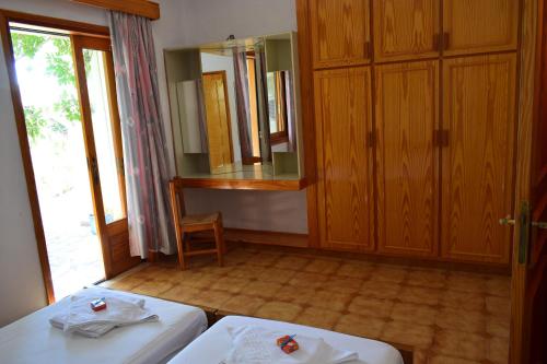 a room with two beds and a mirror at Bellevue Apartments in Sitia