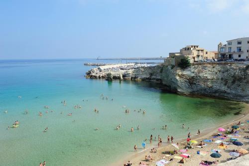 a group of people in the water at a beach at Le Quattro Perle in Terrasini
