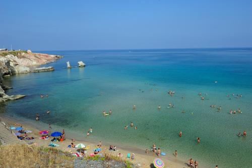 a group of people in the water at a beach at Le Quattro Perle in Terrasini