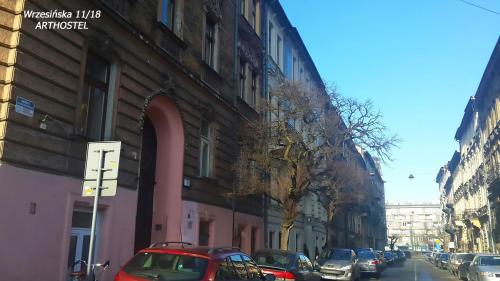 a street with cars parked on the side of a building at Art Hostel in Kraków