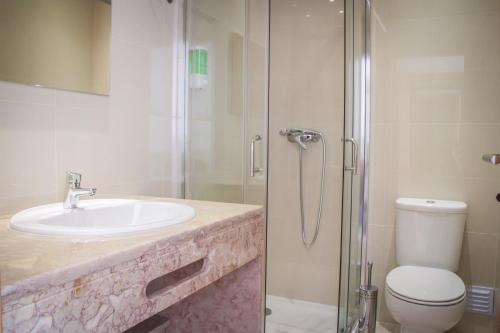 La salle de bains est pourvue d'un lavabo, d'une douche et de toilettes. dans l'établissement Gabana Baleal Beach, à Baleal