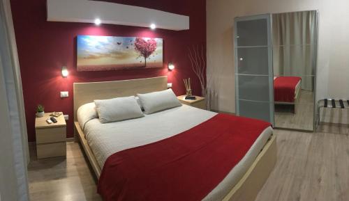 a bedroom with a large bed with a red wall at Il Principe in Ravanusa