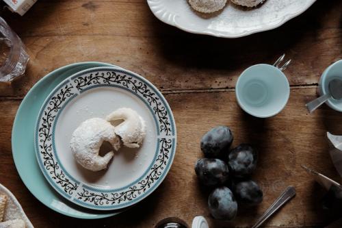 une table sur laquelle est posée une assiette de beignets et de myrtilles dans l'établissement B&B Rosa Dalfonsina, à Villalfonsina