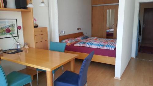 Schlafzimmer mit einem Bett, einem Tisch und Stühlen in der Unterkunft Appartement mit Südbalkon im Haus Feldbergblick in Kappel - Appartement 37 in Lenzkirch