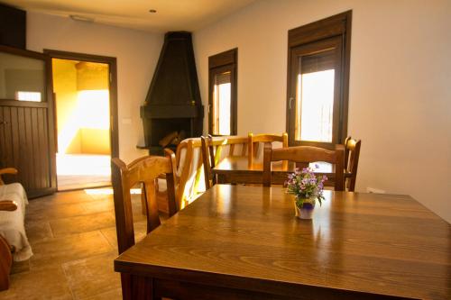 a dining room with a wooden table with flowers on it at Casa Codeta in La Almunia de San Juan