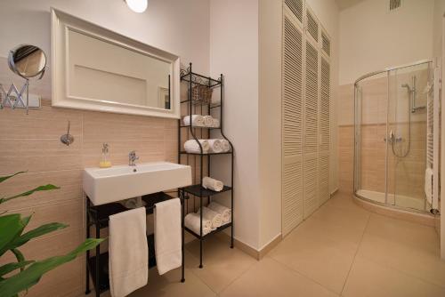 ein Bad mit einem Waschbecken und einer Dusche in der Unterkunft Wishlist Old Prague Residences - New Town in Prag