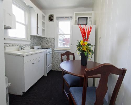 uma cozinha com uma mesa com um vaso de flores em Shore Beach Houses - 38 D Lincoln Avenue em Seaside Heights