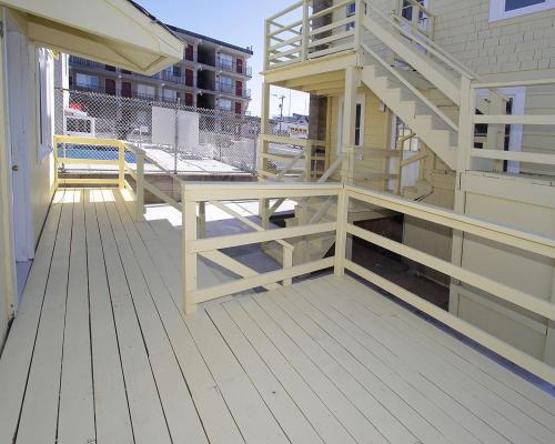 una terraza de madera con una escalera en una casa en Shore Beach Houses - 38 D Lincoln Avenue, en Seaside Heights