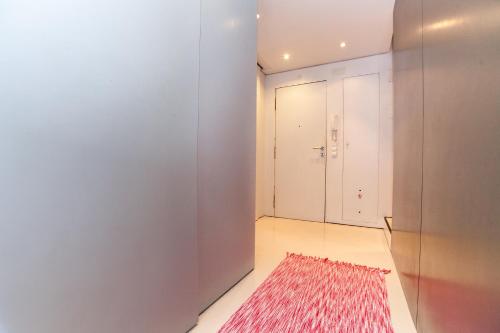 a hallway with a red rug and a white wall at Ana's Design Apartments in Lisbon