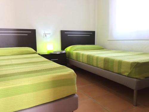 two beds in a room with yellow and green sheets at Torrox Boutique Apartaments - Paraiso Sol in Torrox Costa