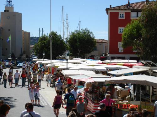 a crowd of people walking around a market with umbrellas at Vic's Land Holidays in Grimaud
