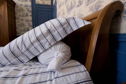 a bed with a pillow with a bow on it at Chambres d'Hôtes Les Foulons in Douai