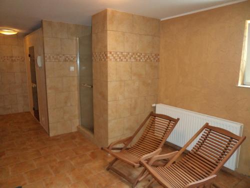 two wooden chairs in a room with a shower at Siedem Świerków in Szczecinek