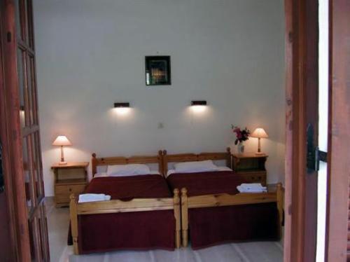 Un dormitorio con dos camas y dos luces en la pared. en Georgina Apartments, en Mesongi