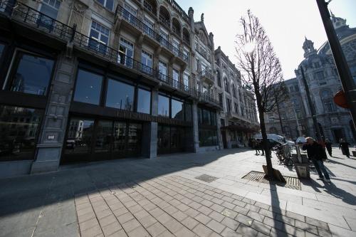 a city street with a tree in front of a building at Renovated Apartment in Antwerp city center in Antwerp