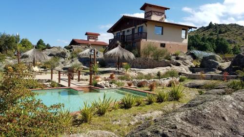 a house on top of a hill with a swimming pool at Aires Serranos - Suites in La Cumbrecita