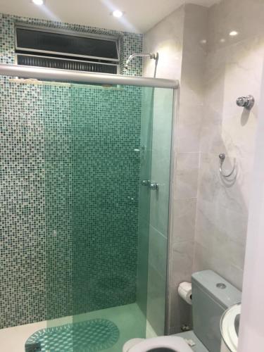 y baño con ducha de cristal y aseo. en Luxuoso deslumbrante 100m da praia, en Río de Janeiro