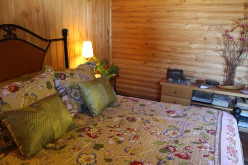 a bedroom with a bed with a wooden wall at B&B Shambala HN in Pelarco